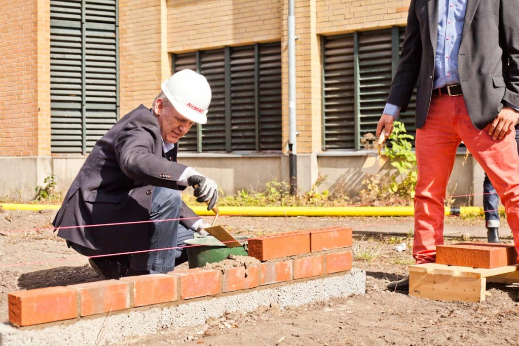 Kommunstyrelsens ordförande Mats Helmfrid lägger cementen på plats till det som ska bli Dammhagen. Foto: Jens Hunt.